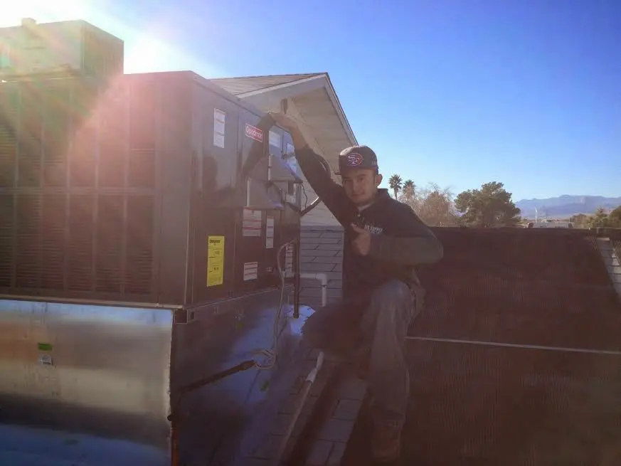 HVAC technician performing Boiler Repair on a rooftop unit in Greensburg